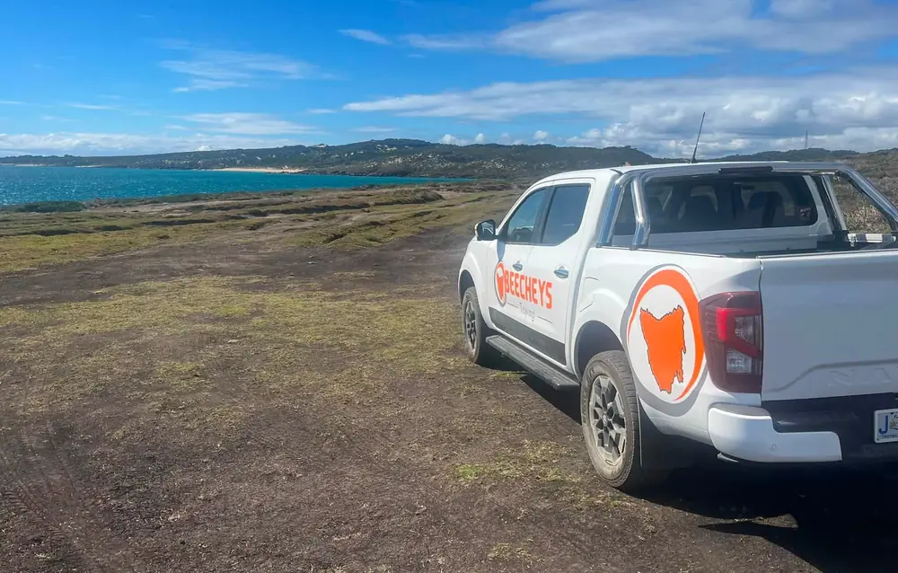 A branded Beecheys Towing ute parked on the Tasmanian coastline