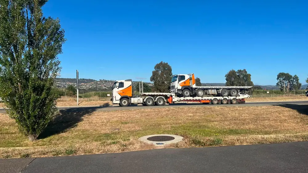 A Beecheys Towing prime mover carrying another truck on a low-loader